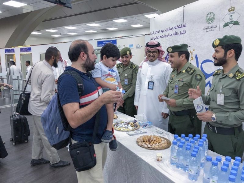 شاهد بالصور.. جوازات مطار الملك عبدالعزيز تعايد المسافرين بالحلوى والهدايا