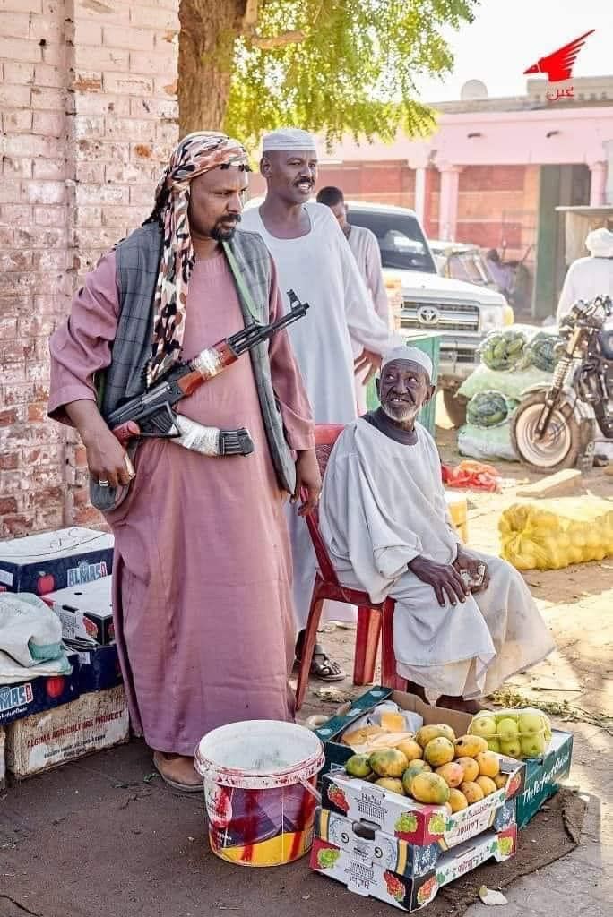 شاهد بالصور.. تجار الخضار وأصحاب المحلات وبائعو “الطعمية” بسوق شندي يحملون السلاح أثناء مباشرتهم لعملهم تحسباً لأي هجوم من “الدعامة”