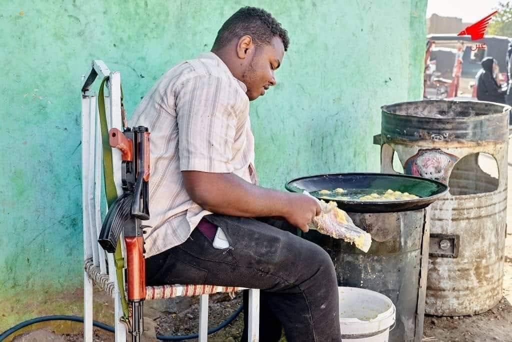 شاهد بالصور.. تجار الخضار وأصحاب المحلات وبائعو “الطعمية” بسوق شندي يحملون السلاح أثناء مباشرتهم لعملهم تحسباً لأي هجوم من “الدعامة”