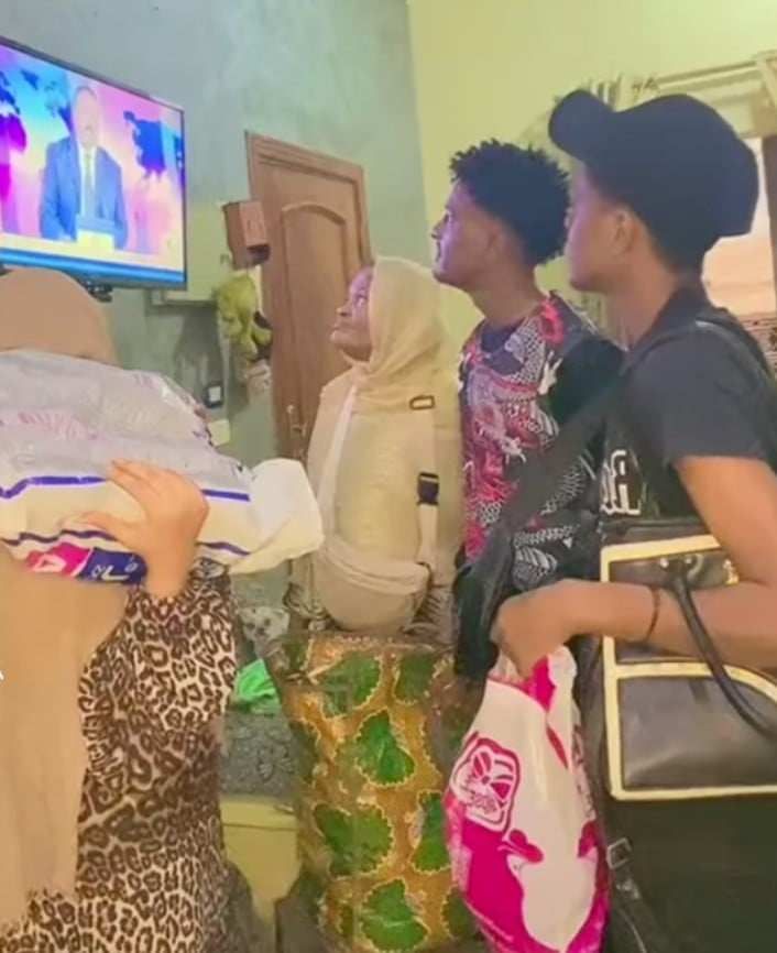 شاهد بالصورة والفيديو.. مقطع مؤثر.. سودانيون في مصر يحملون حقائبهم ويتابعون التلفاز في انتظار تحرير الجيش للخرطوم ليعودوا لمنازلهم